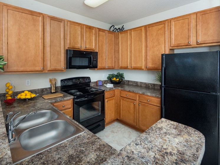 Kitchen With Sink, Refrigerator And Modern Appliances at Abberly Village Apartment Homes by HHHunt, South Carolina, 29169